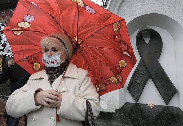 Украинская женщина в медицинской маске участвует в демонстрации перед мемориалом жертвам СПИДа в Киеве, Украина. Украинская женщина в медицинской маске участвует в демонстрации перед мемориалом жертвам СПИДа в Киеве, Украина.