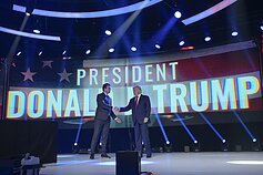 Charlie Kirkas spaudžia Donaldui Trumpui ranką viename iš „Turning Point USA“ renginių