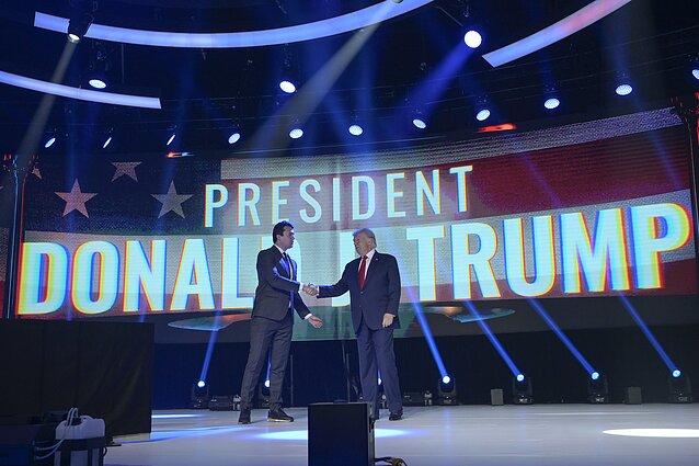 Charlie Kirkas spaudžia Donaldui Trumpui ranką viename iš „Turning Point USA“ renginių