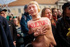 A protester holding a CPR training doll labelled “CULTURE.”