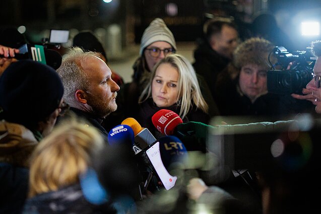 People wait for the return of Belarusian political prisoners outside the US Embassy in Vilnius