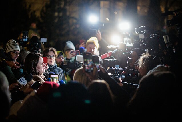 People wait for the return of Belarusian political prisoners outside the US Embassy in Vilnius