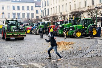 A farmer throws a potato during a demonstration of European farmers outside a gathering of European leaders at the EU Summit in Brussels