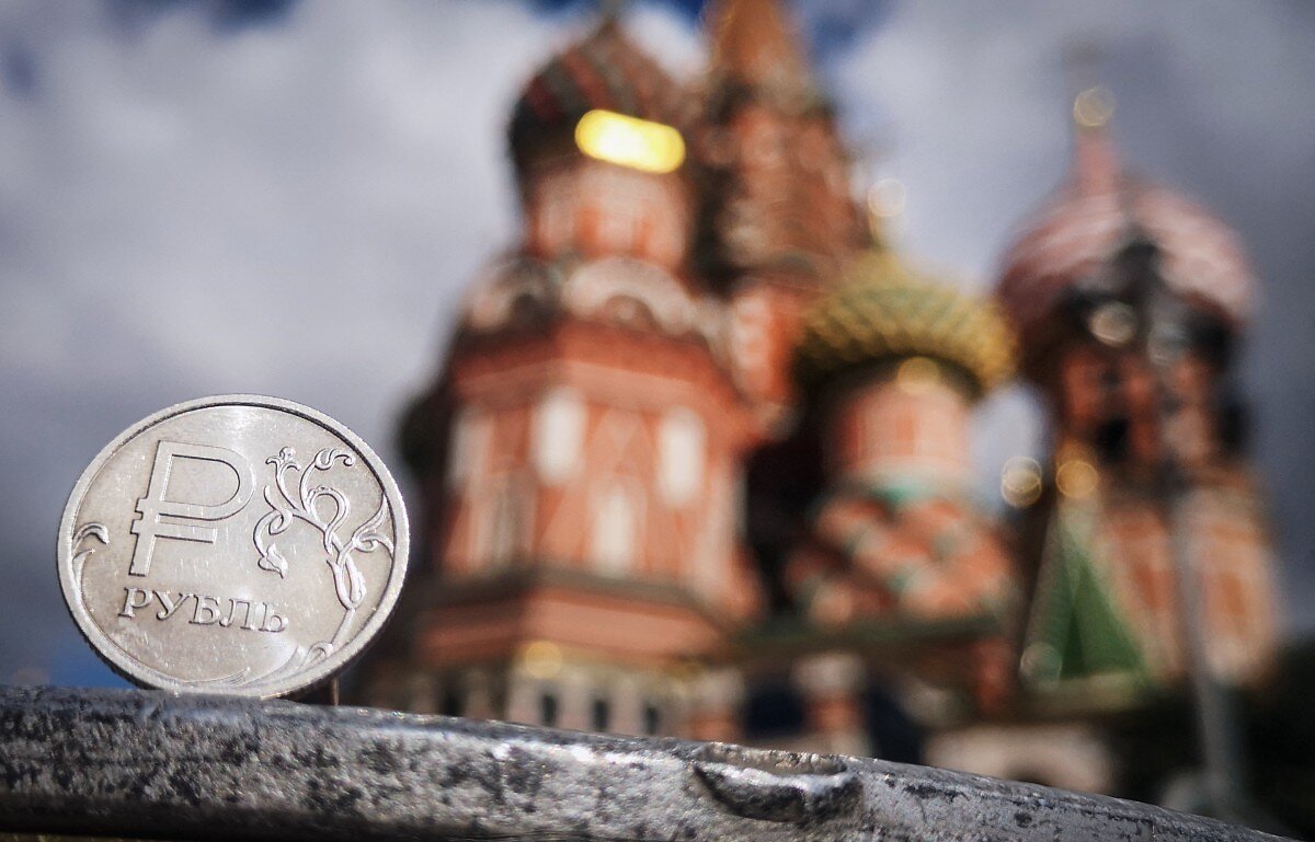 A Russian ruble coin is pictured in front of St. Basil's cathedral in downtown Moscow on September 12, 2025.
