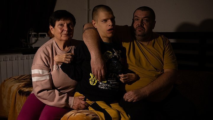 Bohdan with his father Taras and grandmother Nina during a power outage at their home in the Podilskyi district of Kyiv, January 13, 2026.