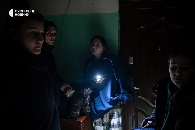 Young people in the dark entrance of a high-rise building.