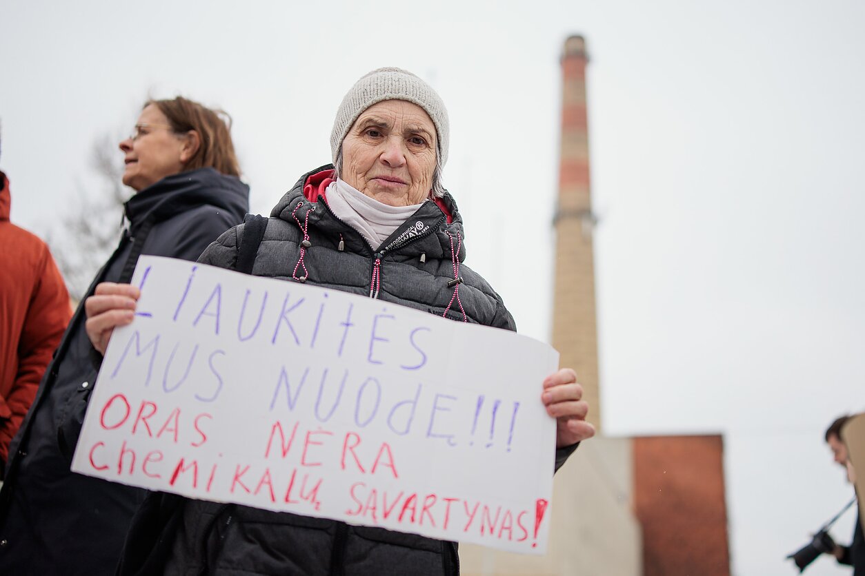 The sign reads "Stop poisoning us. Air is not a dump for chemicals" The sign reads "Stop poisoning us. Air is not a dump for chemicals"