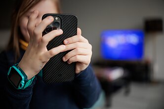 Vaikas su mobiliu telefonu