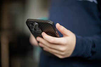 Vaikas su mobiliuoju telefonu