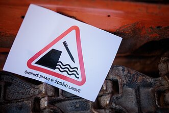 Ant buldozerio prie Seimo atsirado plakatas „Šnipinėjimas nelygu žodžio laisvei“