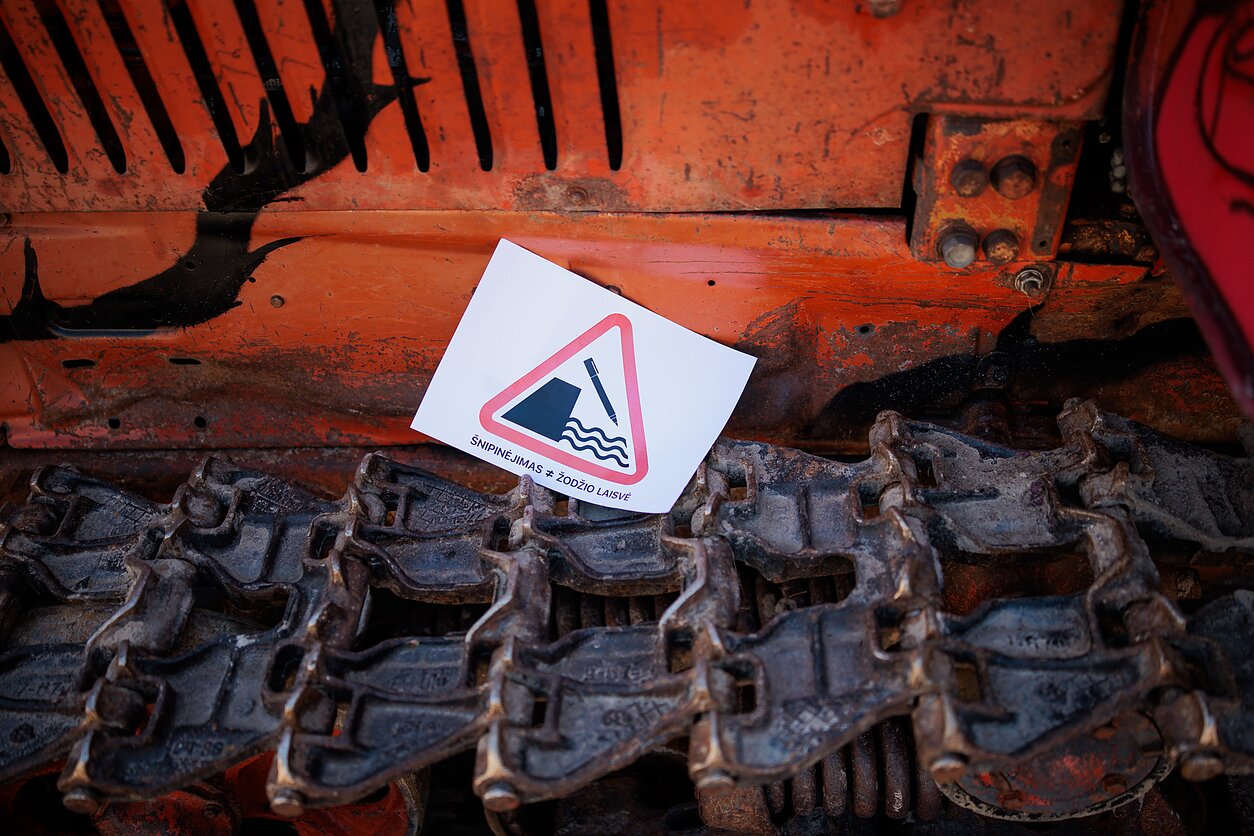 Ant buldozerio prie Seimo atsirado plakatas „Šnipinėjimas nelygu žodžio laisvei“