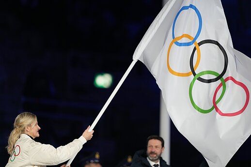 IOC president Kirsty Coventry holding the Olympic flag