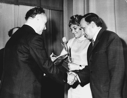 1971 m. scenarijaus autoriams Galinai Dauguvietytei ir Kaziui Bagdonavičiui (dešinėje) įteikiama Sovietų Sąjungos Žurnalistų sąjungos premija už TV pjesių ciklą „Petraičių šeimoje“. 