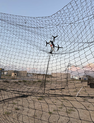 An image released by the Israeli military showing an FPV drone suspended in netting over Israeli military vehicles at an unknown location. An image released by the Israeli military showing an FPV drone suspended in netting over Israeli military vehicles at an unknown location.