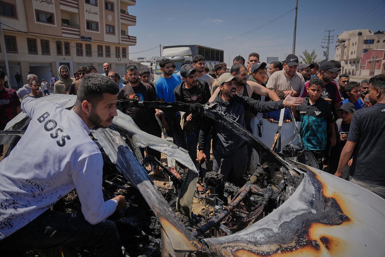 Palestiniečiai Gazos Ruože apžiūri automobilį, į kūrį smogė Izraelis