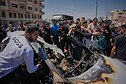 Palestiniečiai Gazos Ruože apžiūri automobilį, į kūrį smogė Izraelis