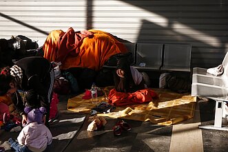 Migranci i uchodźcy siedzą w terminalu pasażerskim w porcie w Pireus pod Atenami Migranci i uchodźcy siedzą w terminalu pasażerskim w porcie w Pireus pod Atenami
