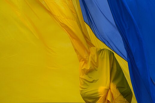 A Ukrainian soldier raises the national flag during a commemoration ceremony