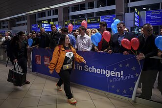 Kobieta mija tablicę z napisem „Witamy w strefie Schengen!”