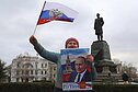 2025 m. kovo 18 d., antradienį, Sevastopolyje, Kryme, moteris mojuoja Rusijos vėliava ir laiko rankose Rusijos prezidento Vladimiro Putino portretą mitinge, skirtame 11-osioms Rusijos įvykdytos Krymo aneksijos metinėms paminėti