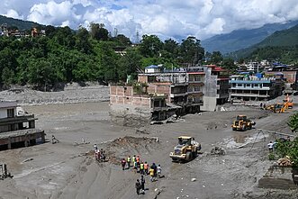 2026 m. rugpjūčio 27 d. savanoriai Trisulyje, Nepalo Nuakoto regione, buldozeriais valo nuo kelio purvą ir nuolaužas po staigių potvynių